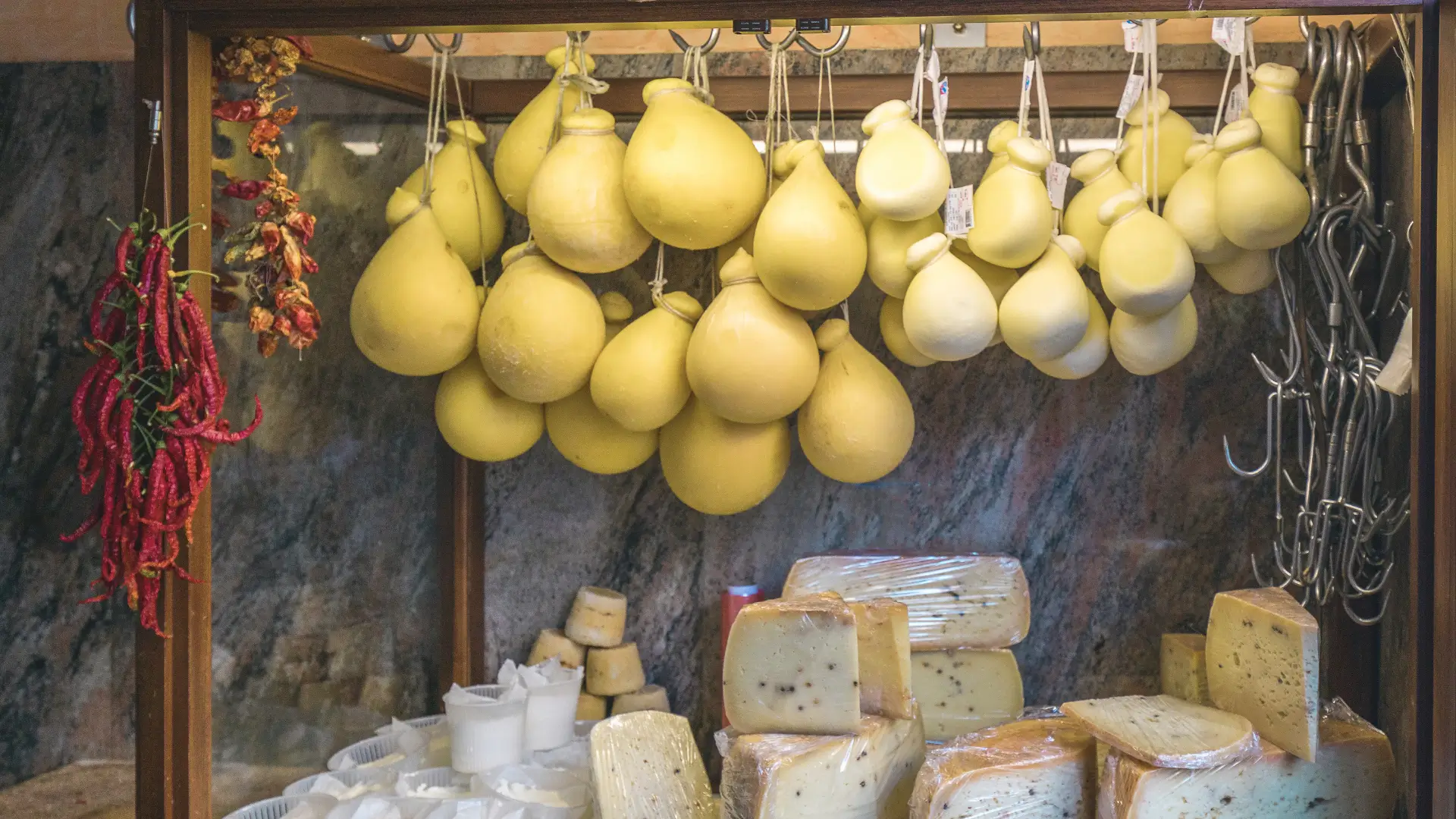 A lively scene at Palermo’s Ballarò market, showcasing colourful stalls full of traditional Sicilian cheese. The bustling energy and vivid colours embody the culinary and cultural vibrancy of the Mediterranean island
