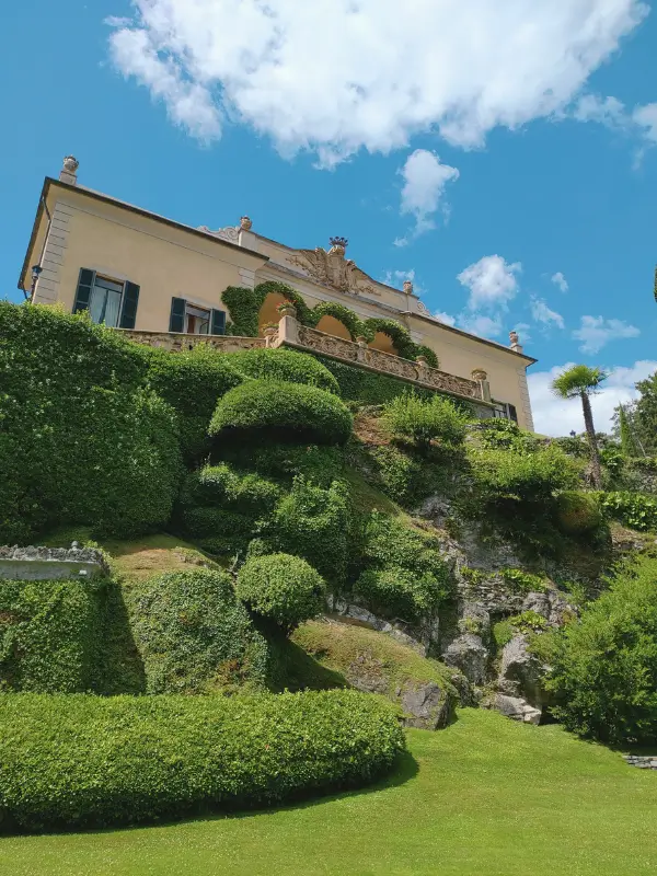 Villa del Balbianello framed by greenery and blooming spring gardens on Lake Como, Italy