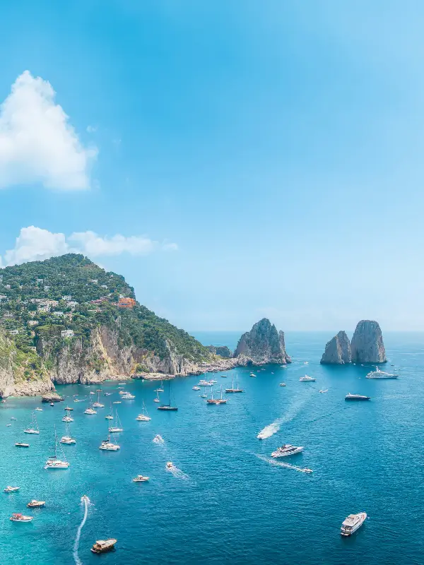 The Capri faraglioni rock formations rising from the Mediterranean under a summer sky