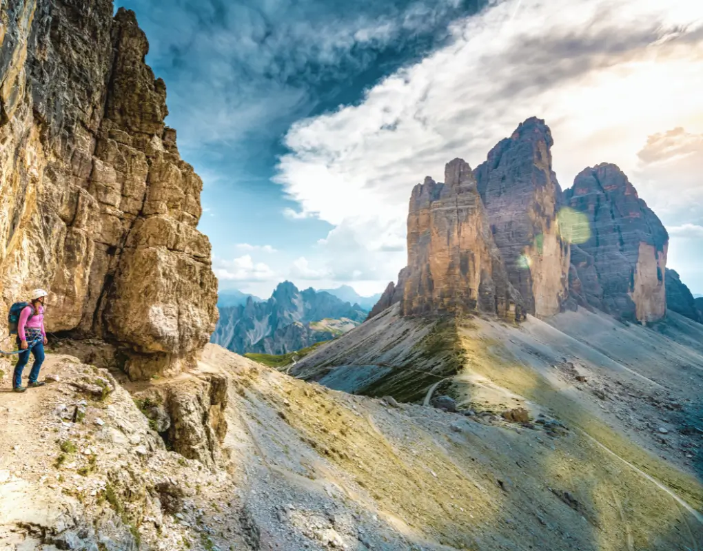 A climber with via ferrata gear overlooking the Dolomites on a holiday with grown-up kids.