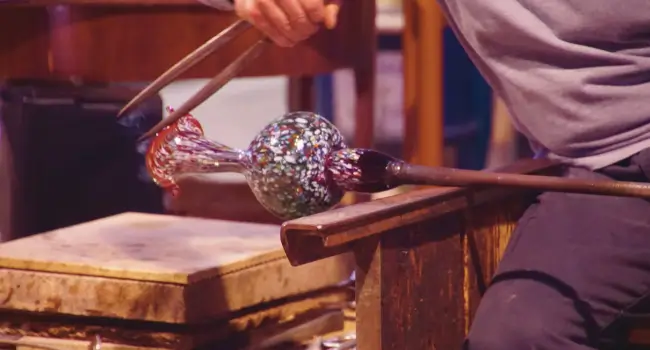 Artisan working with glass in Murano, an authentic experience for an anniversary trip