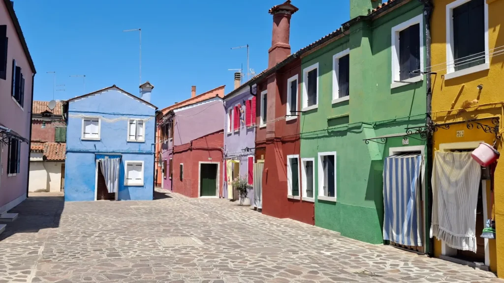 Painted houses and hanging laundry on a street in Burano