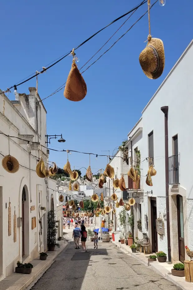 A street of hanging straw hats outside the shops in Alberobello, Puglia