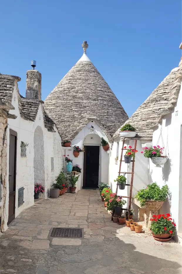 A flower-covered trullo in Alberobello, Puglia, in the town's quiet back lanes