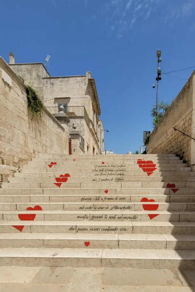 A staircase decorated with handwritten poetry and red hearts in Alberobello, Puglia