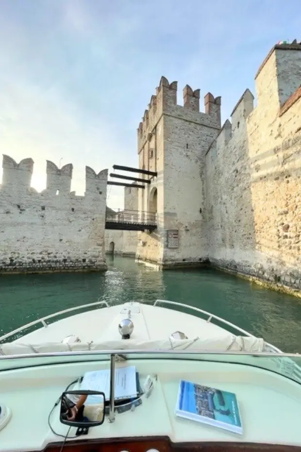 Private boat arriving at Sirmione Castle on the shores of Lake Garda