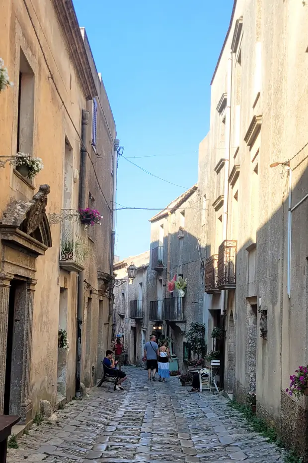 Narrow cobblestone street lined with medieval houses in Erice.