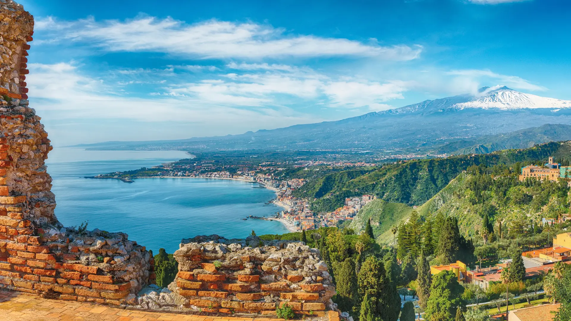 Panoramic view of Taormina’s ancient ruins with Mount Etna and the Ionian Sea in the background, as an Amalfi Coast alternative