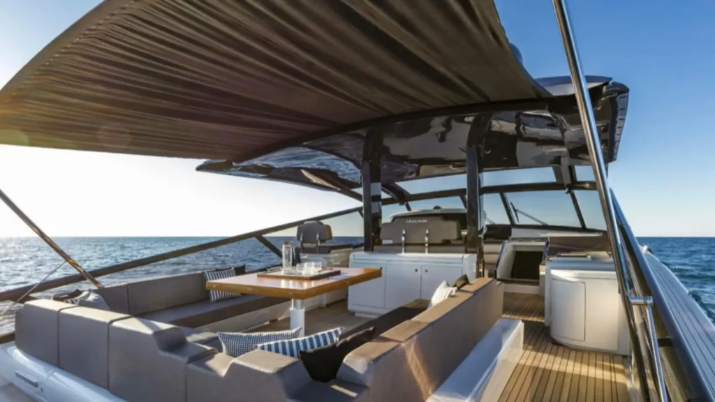 Luxury private yacht deck with cushioned seating and teak flooring set up for lunch on board during a family yacht charter along the Amalfi Coast Italy