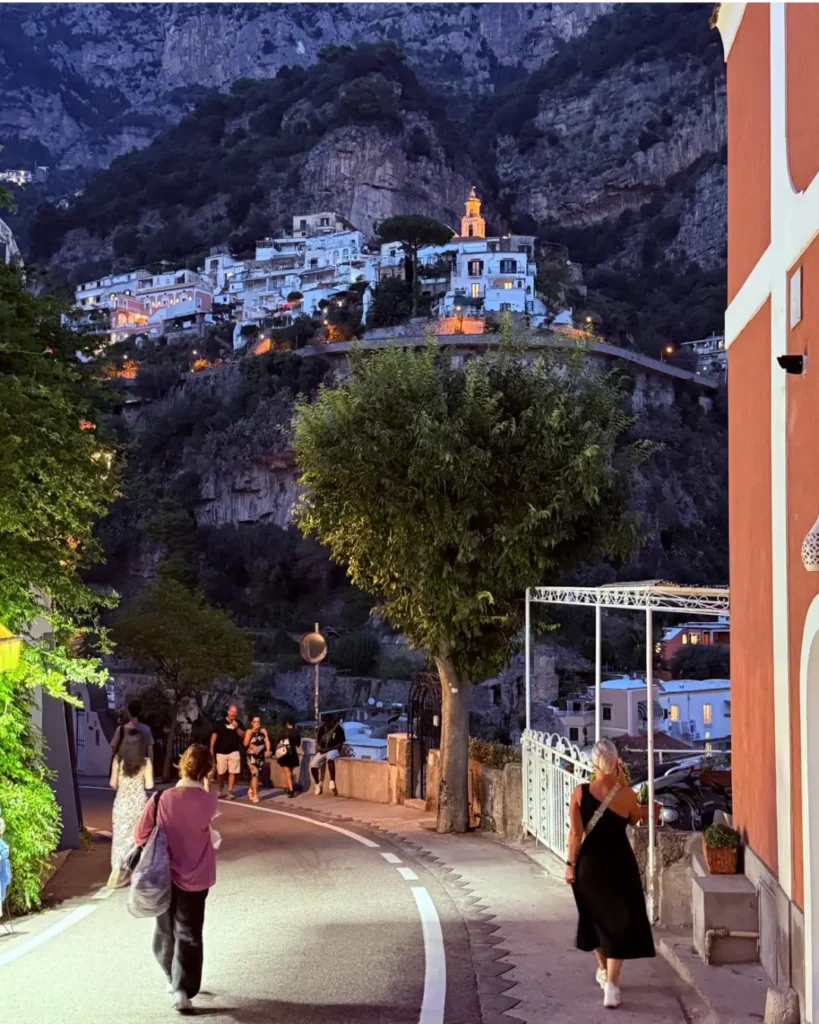 A street in Positano in the evening with the lit town.